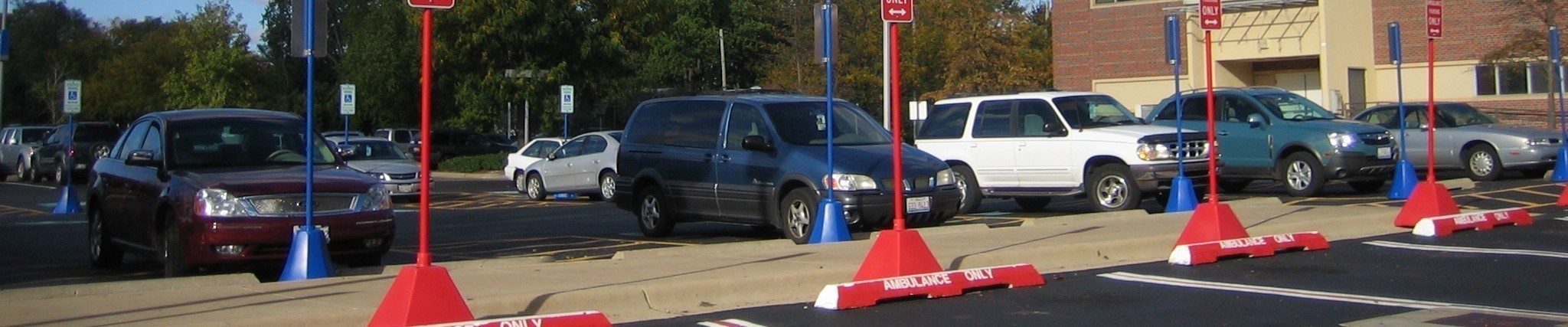 Image is of portable sign posts and bases on poles in a parking lot 