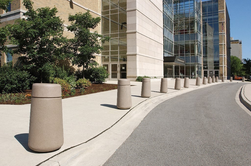 Numerous round cement bollards in a semicircle