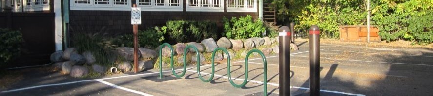 Site furnishings including a bike rack and bollards in a parking lot
